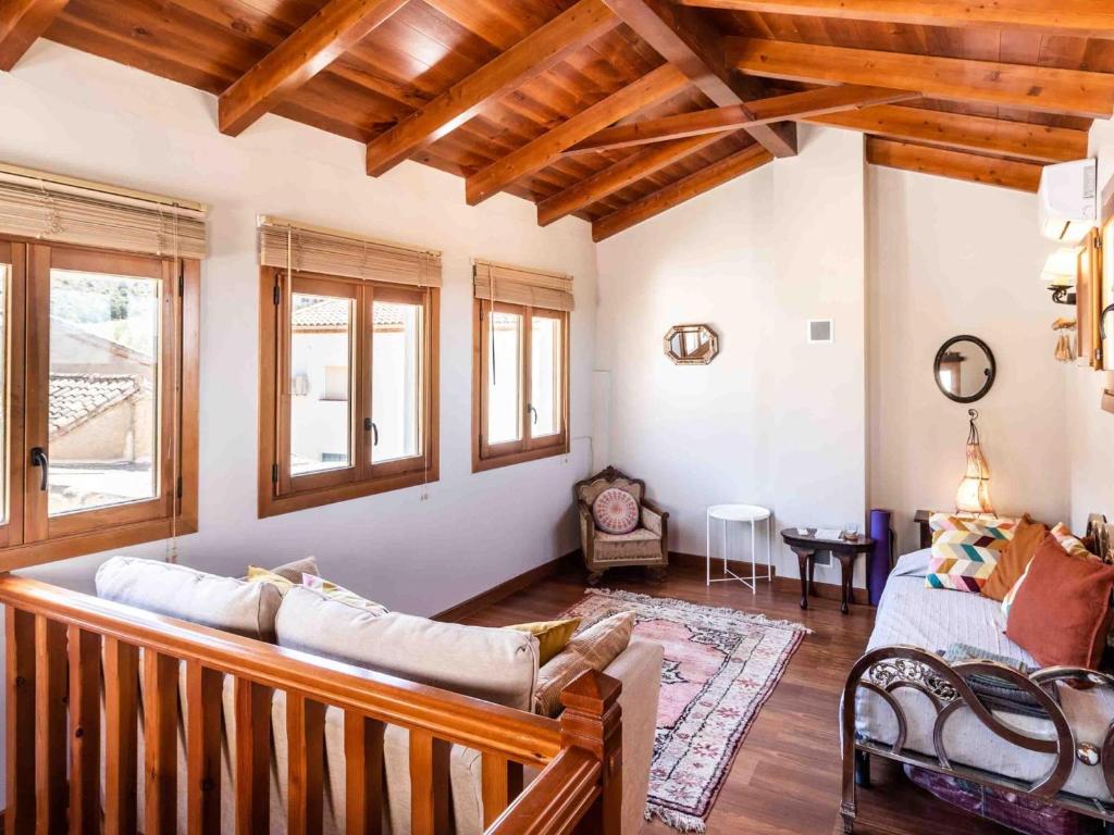 salon z drewnianymi sufitami i kanapą w obiekcie Casa El Sarük w mieście Nigüelas