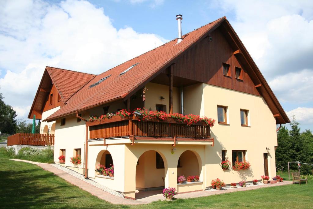 a house with a brown roof and a balcony at Penzion Kvítko in Vacov