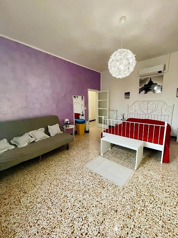 - un salon avec 2 lits et un mur pourpre dans l'établissement 'La Casina Di Clara' - Livorno free parking!', à Livourne