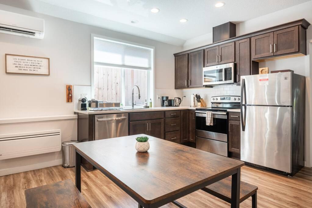 a kitchen with a table and a stainless steel refrigerator at Walkable Apt Next to Restaurants, Bars, and Shops! in Portland