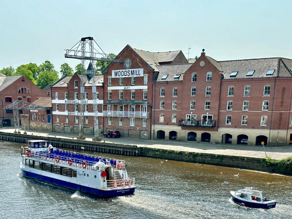 ein Boot auf dem Wasser vor einem Gebäude in der Unterkunft Riverside Apartment at Woodsmill Quay in York
