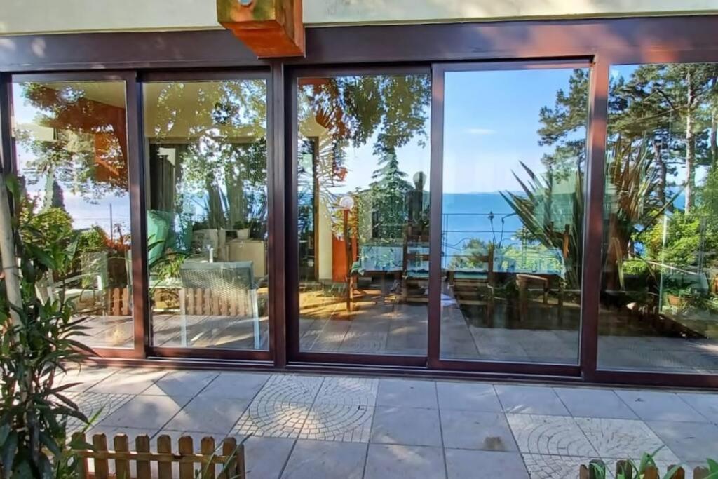 a glass house with a view of the ocean at Brezza Marina - Appartamento in villa fronte mare in Trieste