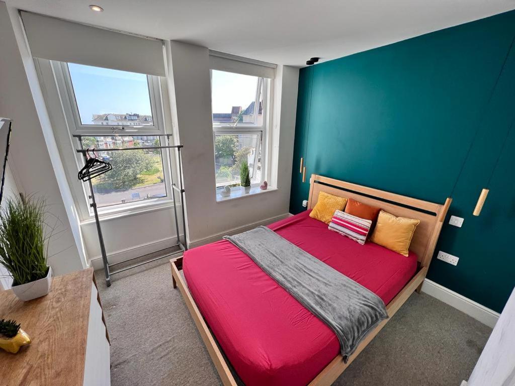 - une chambre avec un lit rouge et un mur vert dans l'établissement Born Park, à Bournemouth