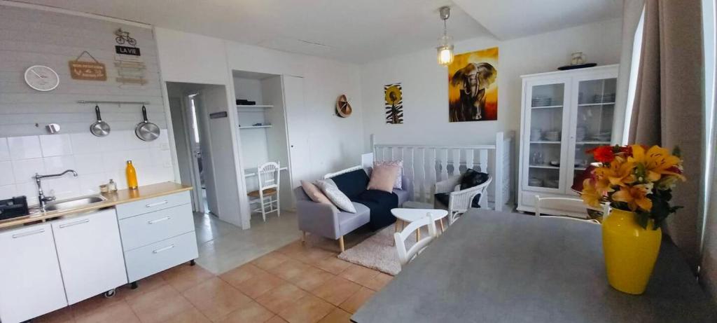 une cuisine et un salon avec un vase de fleurs dans l'établissement 