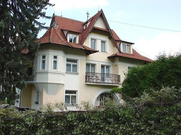 una gran casa blanca con techo rojo en Hotel Lužná, en Luhačovice