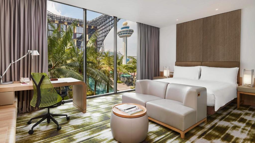 a hotel room with a bed and a desk and a chair at Crowne Plaza Changi Airport by IHG in Singapore