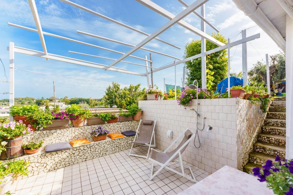 eine Terrasse mit einem Haufen Topfpflanzen und einem Stuhl in der Unterkunft casetta mariapia in Procida