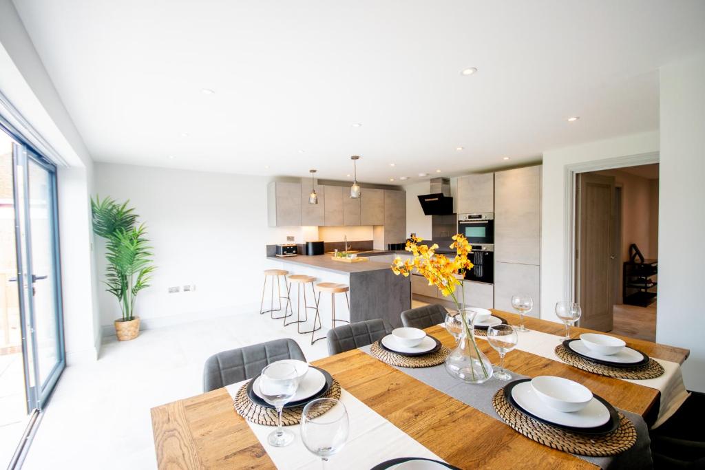 una sala da pranzo e una cucina con tavolo e sedie di Princes Close - Spacious Modern Luxury Home a Windsor
