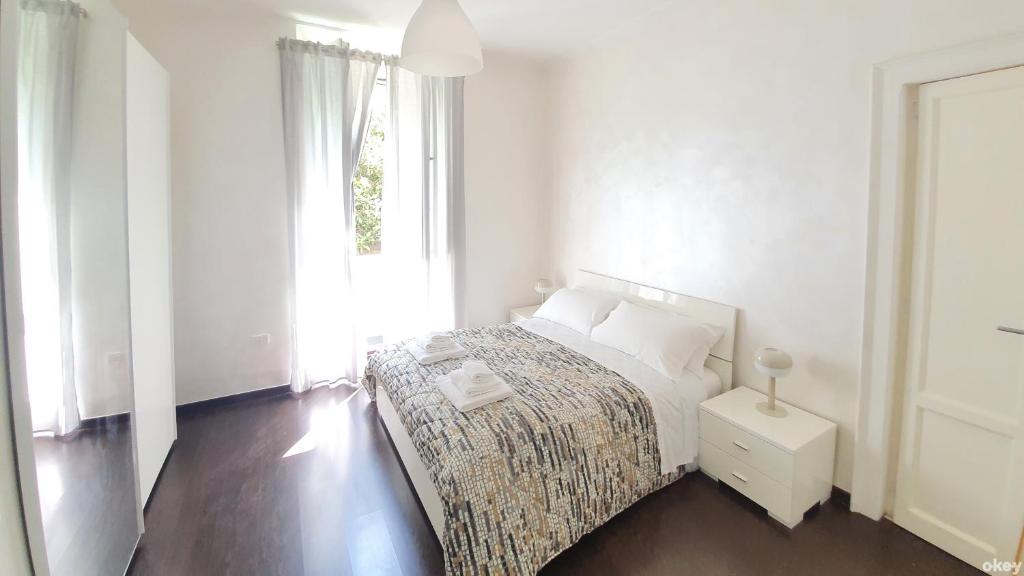 een witte slaapkamer met een bed en een raam bij Star House - Bari Centro in Bari