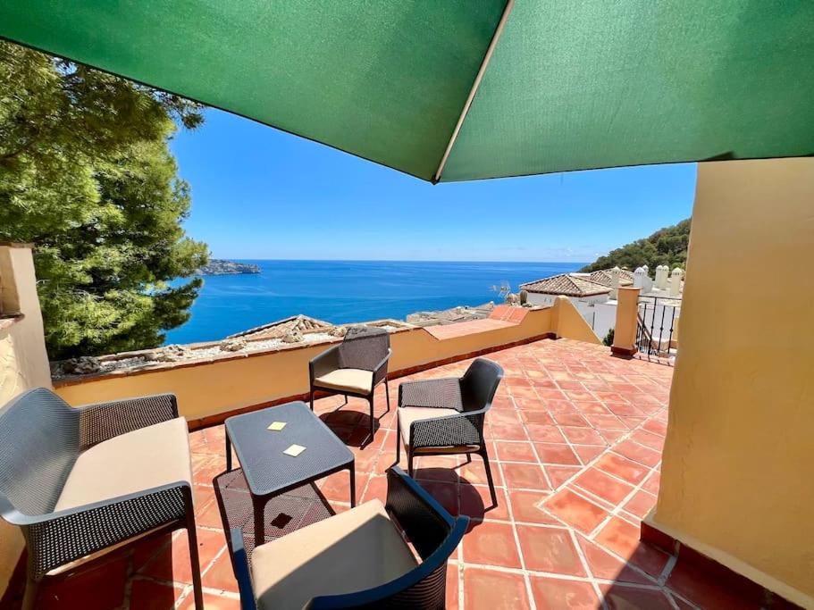 eine Terrasse mit Stühlen und Tischen und Meerblick in der Unterkunft Chalet Tropical Bay Views in La Herradura