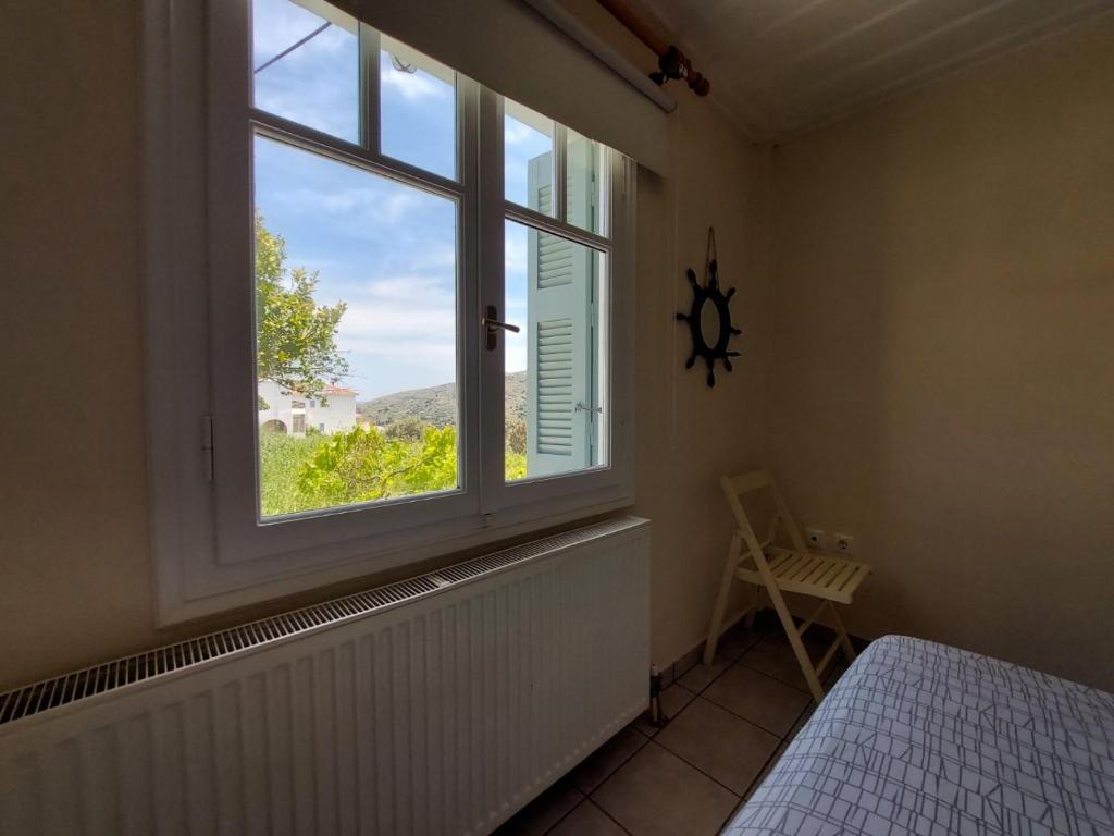 sypialnia z oknem z łóżkiem i widokiem w obiekcie Palaiokrassa sunny appartment w mieście Andros
