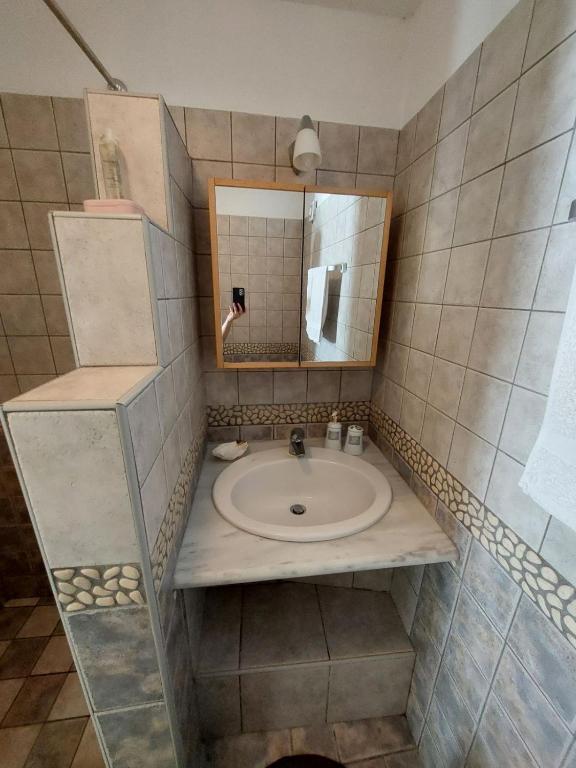łazienka z umywalką i lustrem w obiekcie Palaiokrassa sunny appartment w mieście Andros