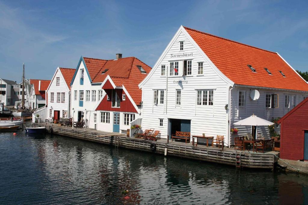 a row of houses on a dock next to the water at Norneshuset Overnatting in Skudeneshavn