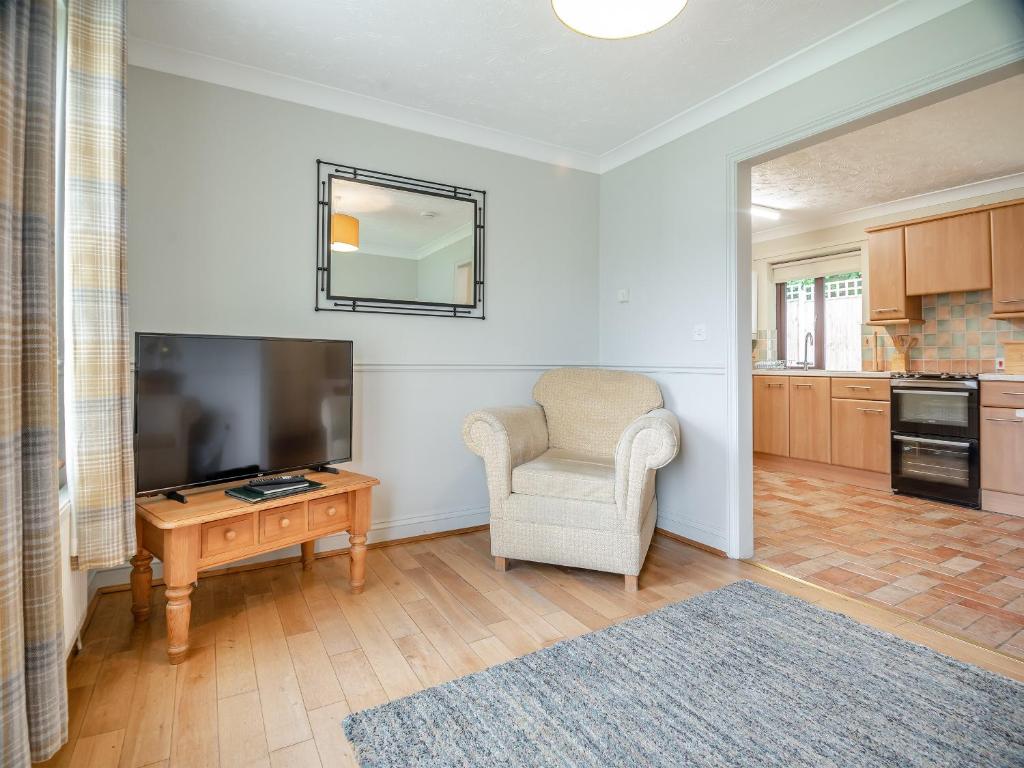 a living room with a television and a chair at Clover Cottage - W40835 in Horsford