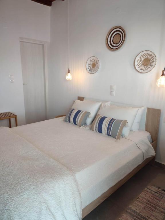 a bedroom with a large white bed with two pillows at Studios Betty in Plaka Milou