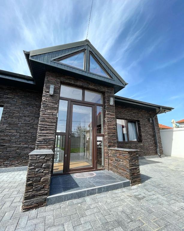 a brick house with a large glass door at BLACK SEA HOUSE in Vama Veche