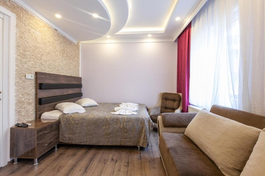 a bedroom with a bed and a couch at LALE SULTAN SÜİT APART in Istanbul