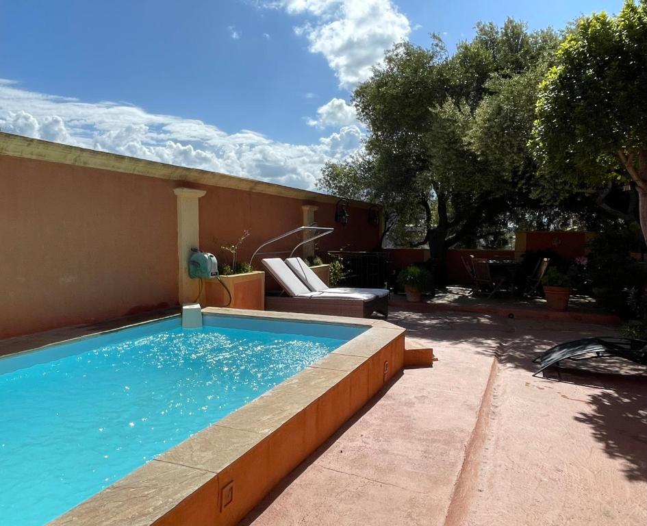 een zwembad in een tuin naast een huis bij Villa ANTONIA in Calvi