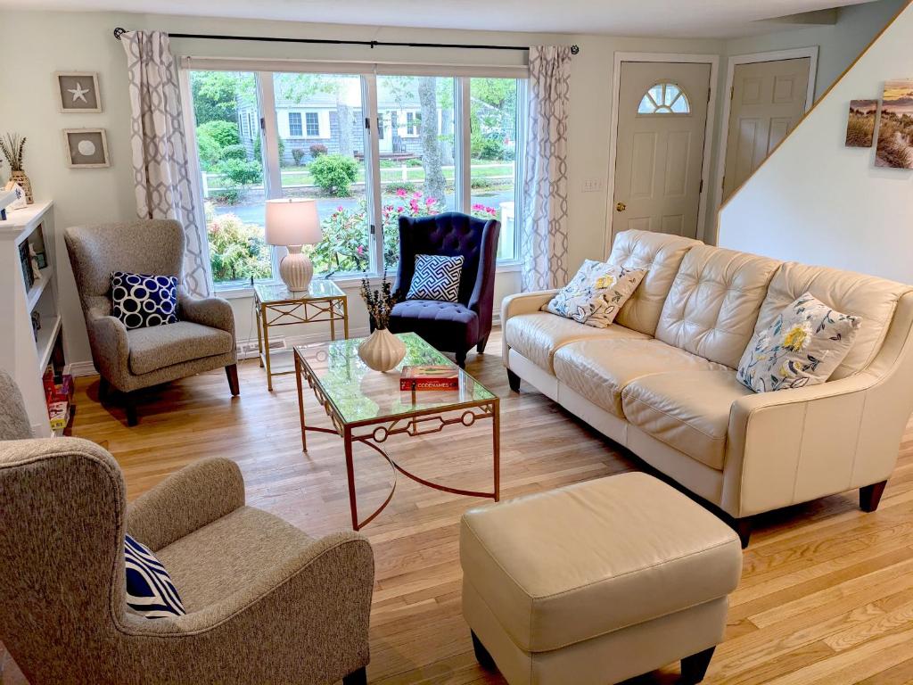 a living room with a couch and chairs and a table at Spacious 4BR house on a quiet street in Centerville 5 min to Craigville beach in Centerville