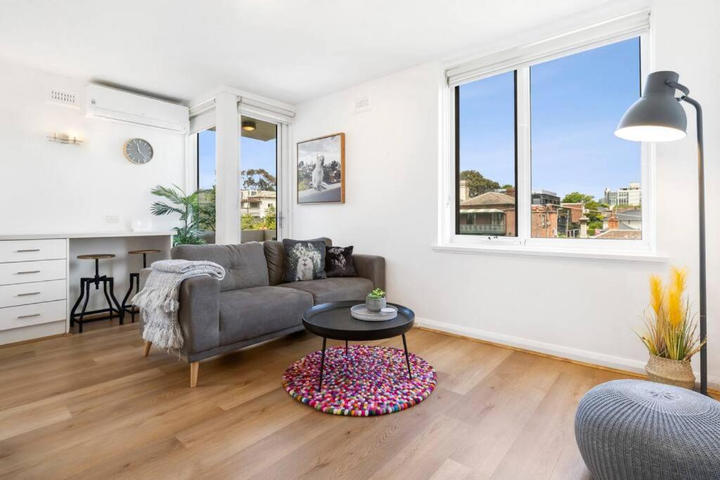 uma sala de estar com um sofá e uma mesa em South Yarra apartment with stunning views em Melbourne