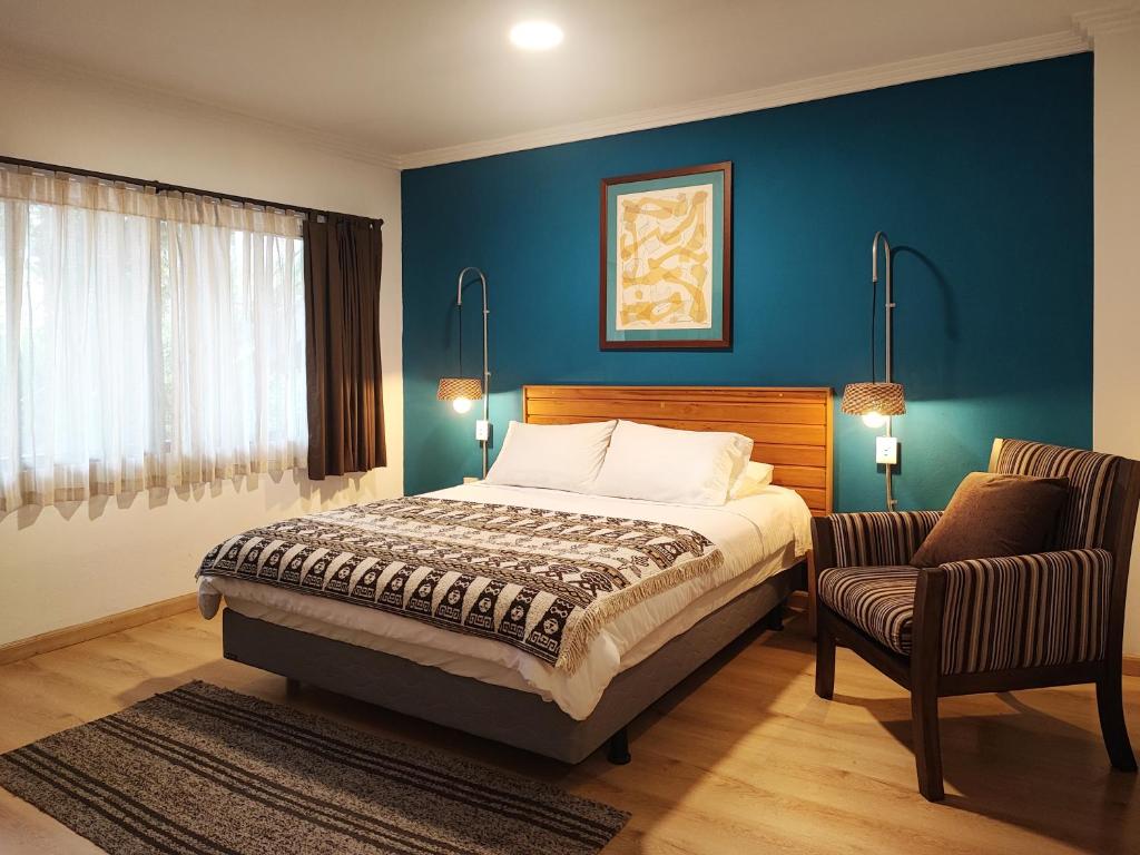 1 dormitorio con 1 cama y 1 silla en Hotel Casa Merced, en Cuenca