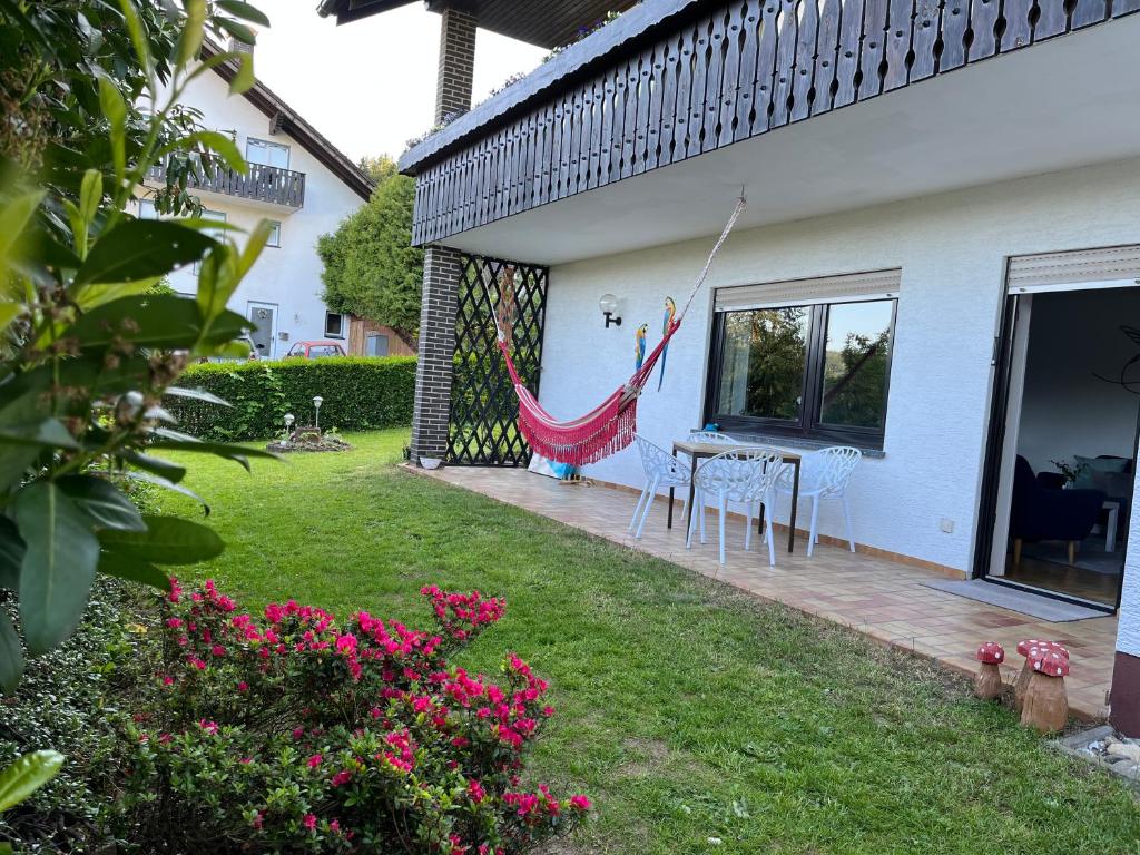 a patio with a hammock on the side of a house at Familienglück im Odenwald in Grasellenbach