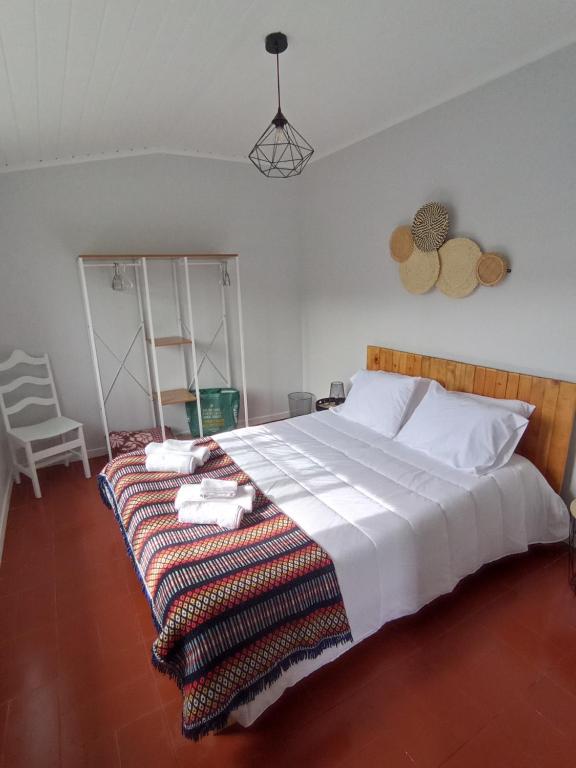 a bedroom with a large bed with a blanket on it at Villa Visconde in Nordeste