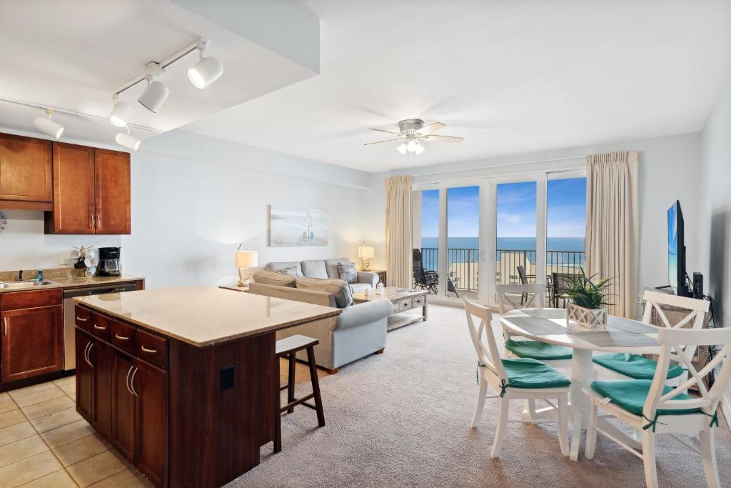 a kitchen and living room with a table and chairs at Spacious Resort Condo with Breathtaking Gulf Views! by Dolce Vita Getaways PCB in Panama City Beach