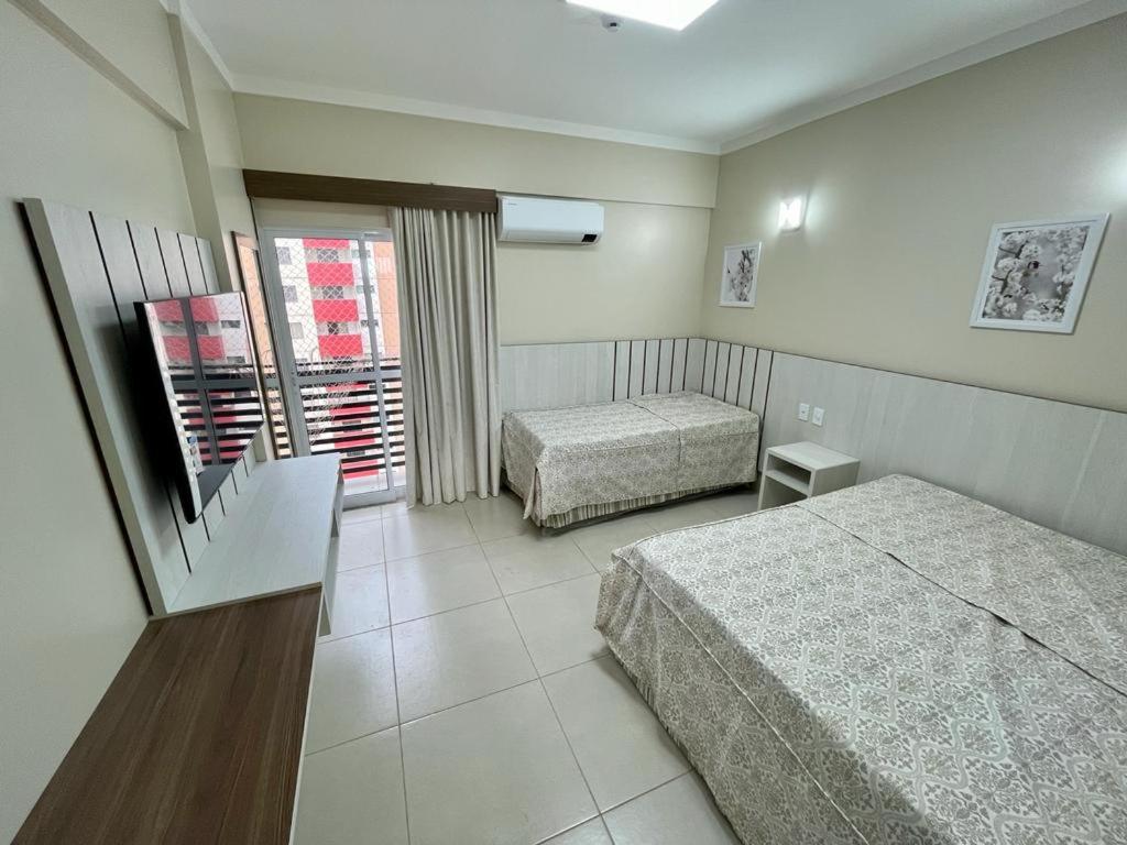 ein Hotelzimmer mit zwei Betten und einem Fenster in der Unterkunft Com CAFE SPAZZIO DIROMA e ACESSO ao ACQUA Parque DIROMA TODOS OS DIAS in Caldas Novas