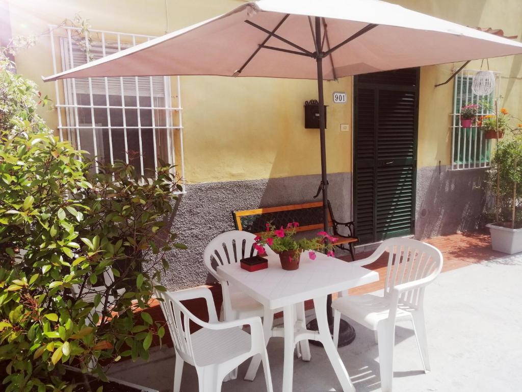 une table et des chaises blanches avec un parasol dans l'établissement Pierina, à Lucques