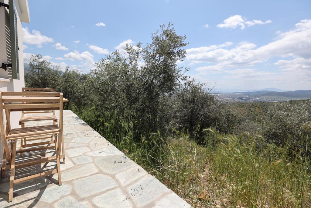 a wooden bench sitting on the side of a house at Little house in the olive grove in Melissátika