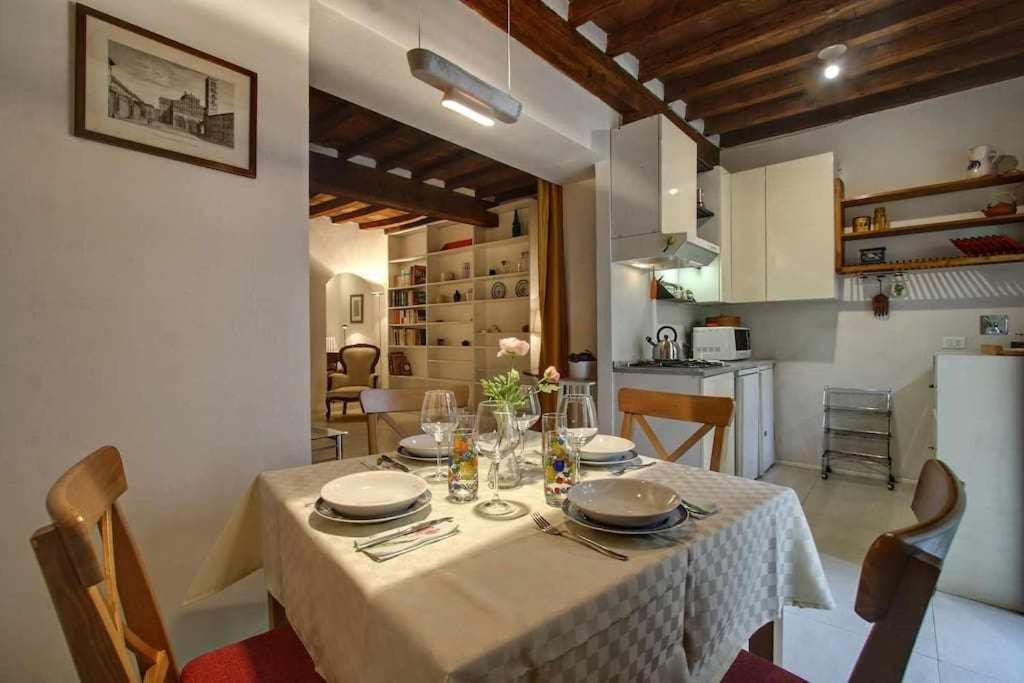 a dining room table with a white table cloth and chairs at Il Tulipano Apartment With Patio in Florence