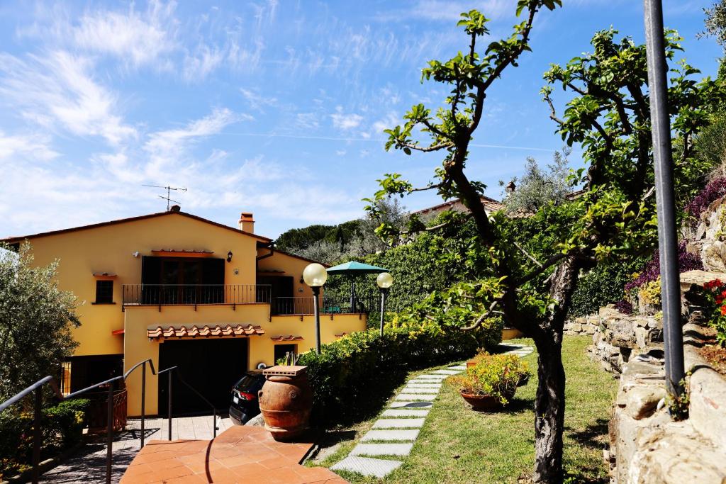 una casa amarilla con entrada y patio en Bed and Berli, en Sesto Fiorentino