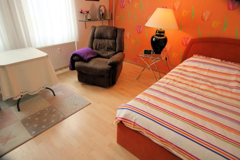 ハノーファーにあるApartment in Kronsbergのベッドルーム1室(ベッド1台、椅子、ランプ付)