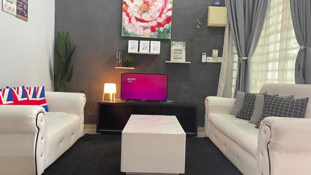 Chempaka Kluang Homestay في كلوانج: غرفة معيشة مع كنبتين بيضاء وتلفزيون