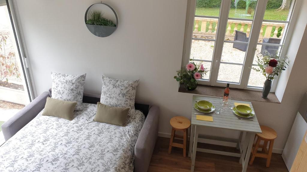 a small bedroom with a bed and a table at Château Puygrenier in Villefranche-de-Longchat