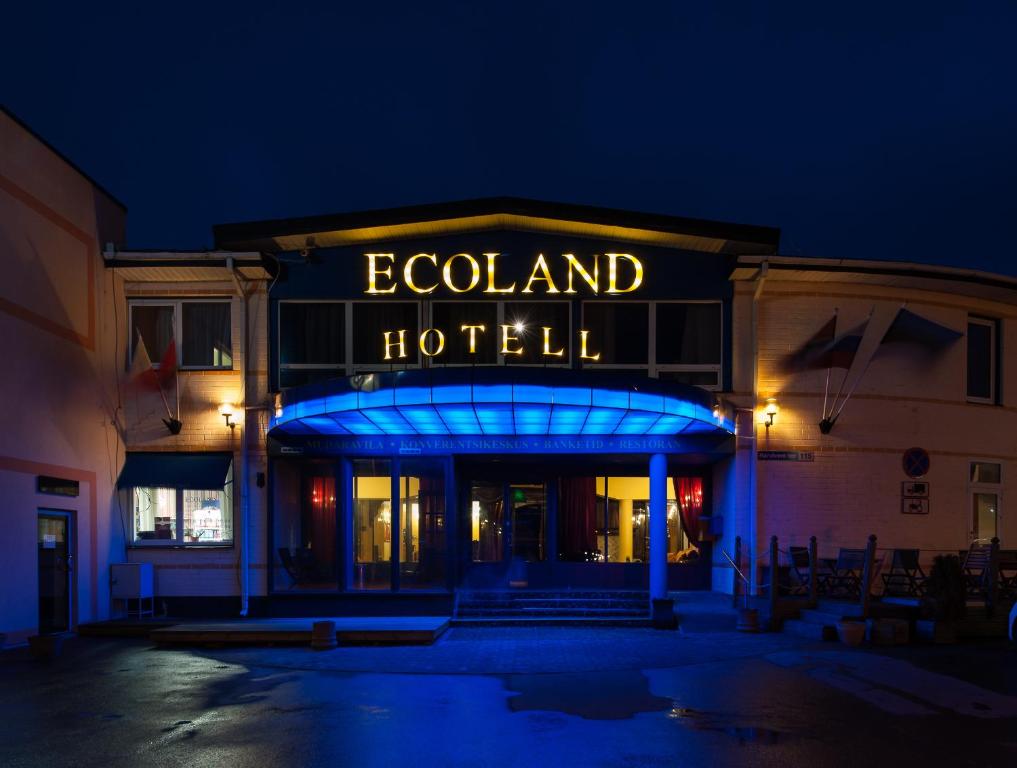 a building with a sign that reads egoland hotel at night at Ecoland Hotel in Tallinn