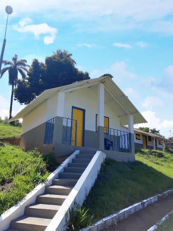 a small white house with stairs in front of it at Pousada e Restaurante Victórios in Caeté