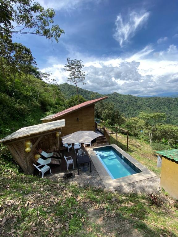 uma casa com piscina e uma cabana em HOTEL RESERVA DONATO em Nocaima