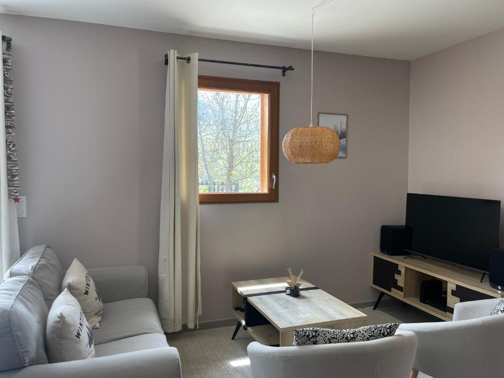 un salon avec un canapé et une télévision dans l'établissement Appartement au centre de St Martin de Belleville, à Saint-Martin-de-Belleville