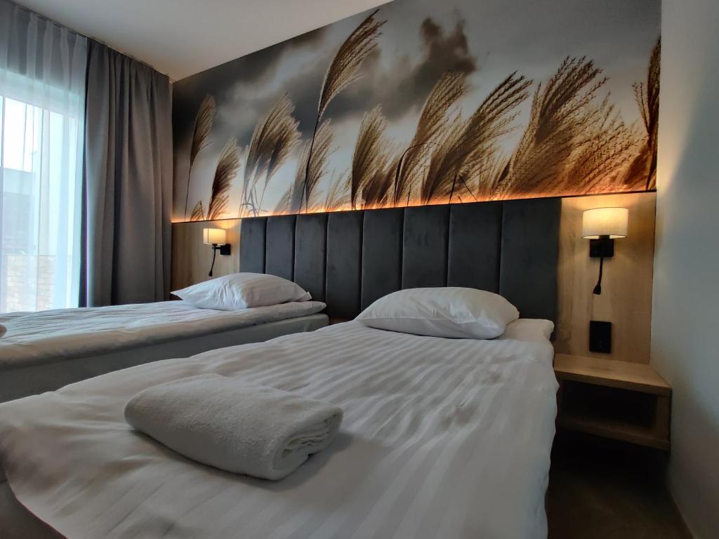 duas camas num quarto de hotel com um quadro na parede em Nowe M4 Żyrardów Centrum - blisko Suntago em Żyrardów