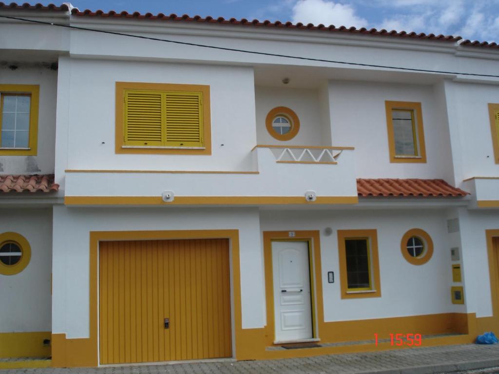 una casa con dos garajes y puertas amarillas en Costa do Moinho, en Longueira