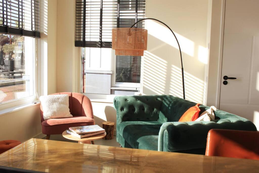 uma sala de estar com dois sofás verdes e uma mesa em The Comfort of a Luxury Hotel, but with your own fully equipped Kitchen em Loosdrecht