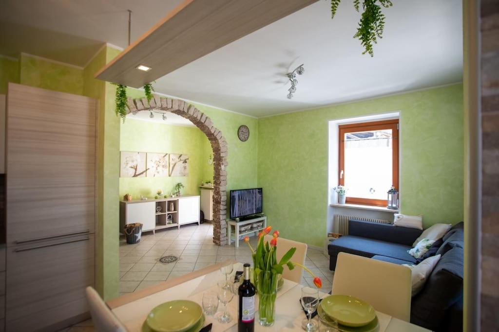 a living room with green walls and a blue couch at *[Stella Alpina]*accogliente casa, giardini, wi-fi in Borgo Lares