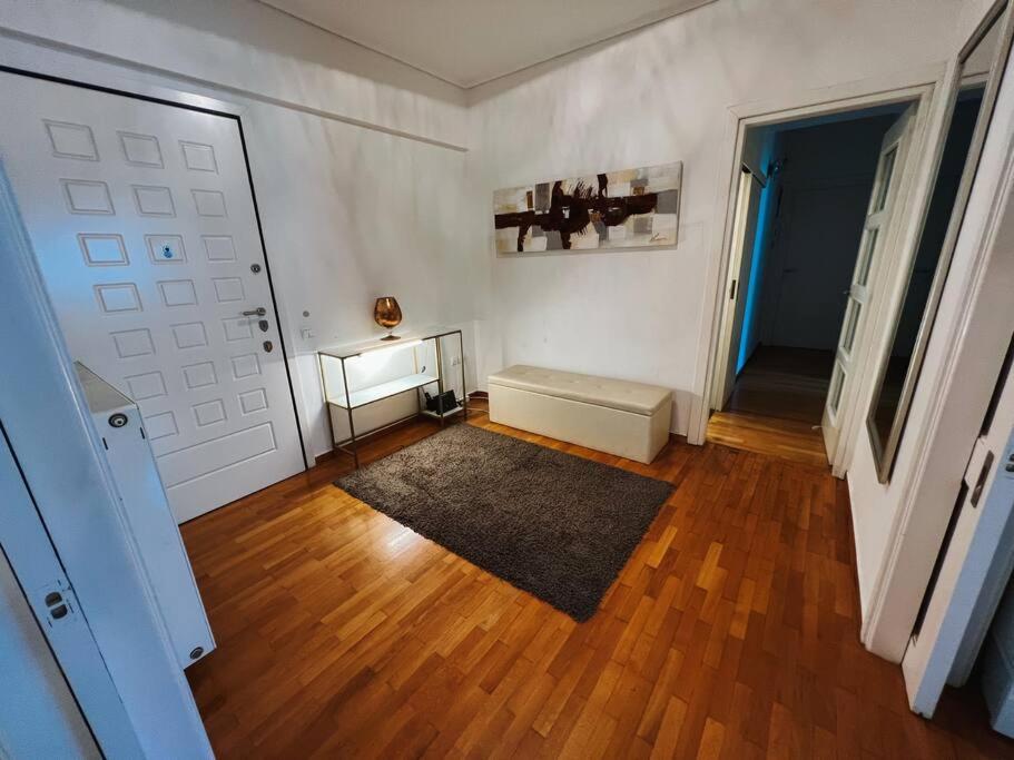 Cette chambre dispose d'une porte blanche et de parquet. dans l'établissement Glyfada Prime Location Spacious Apartment, à Athènes