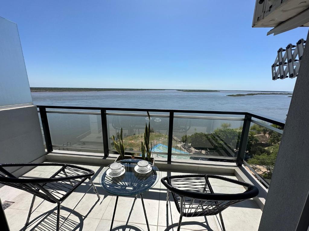 a balcony with chairs and a table and the ocean at Departamento en Corrientes in Corrientes