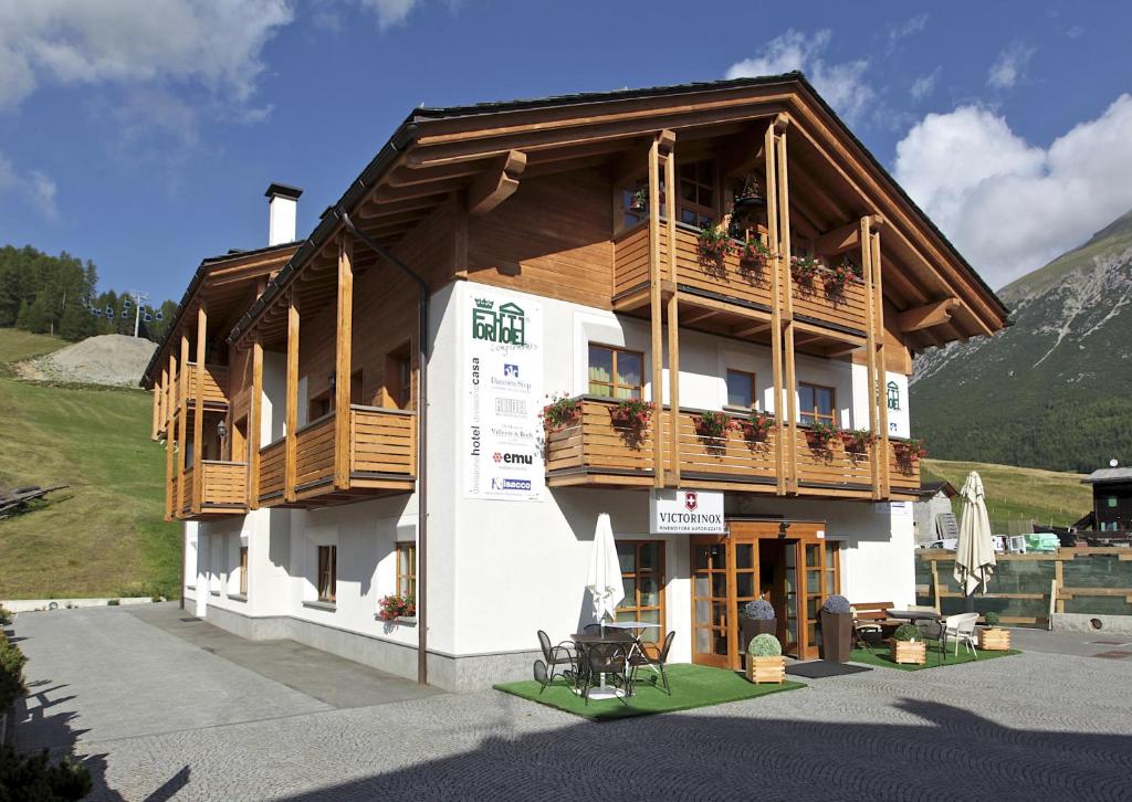 a large building with a balcony and a table at Appartamenti Forhotel in Livigno
