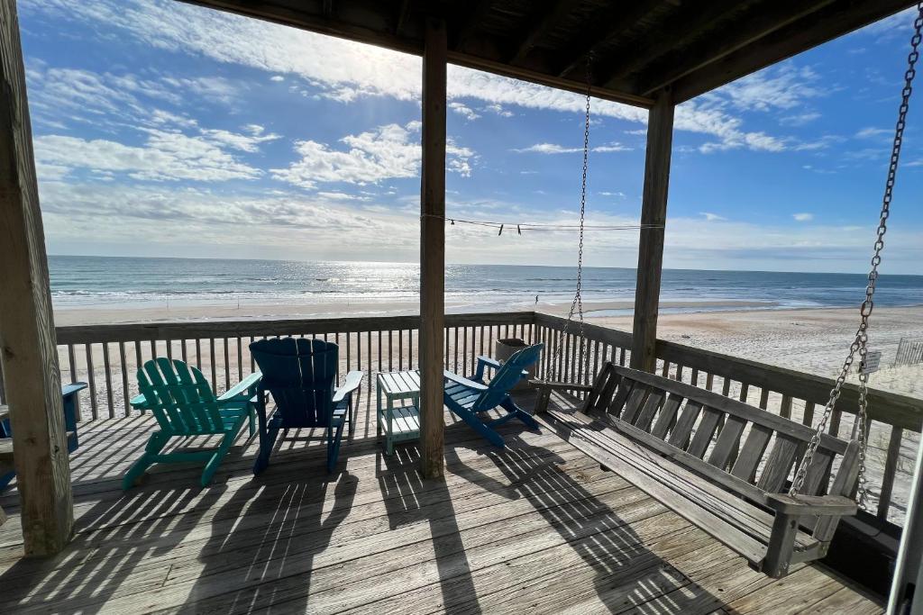 een veranda met 2 stoelen en het strand bij Seashore's Best in North Topsail Beach