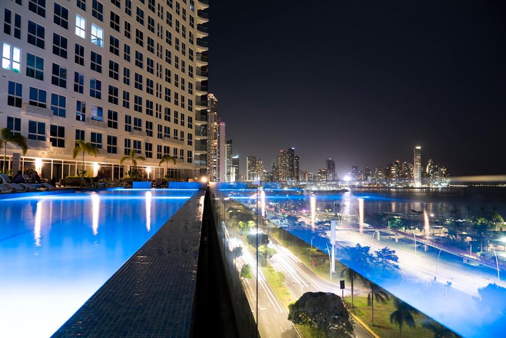 a view of a city at night with blue lights at private ocean view studio apartment in Panama City