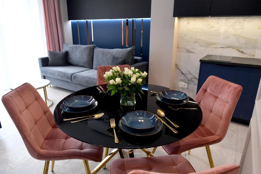 ein Wohnzimmer mit einem Tisch und einer Blumenvase in der Unterkunft CoCo Elite Apartments Zator in Zator